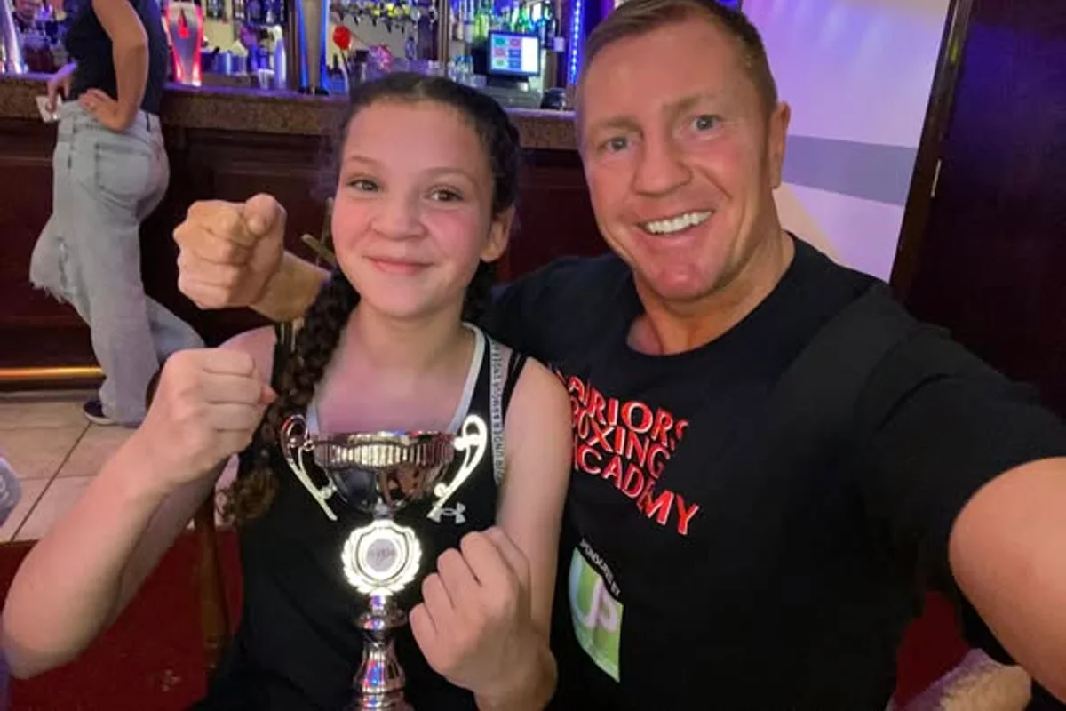 Young Warriors Boxing Academy fighter with trophy and head coach Scott Walker