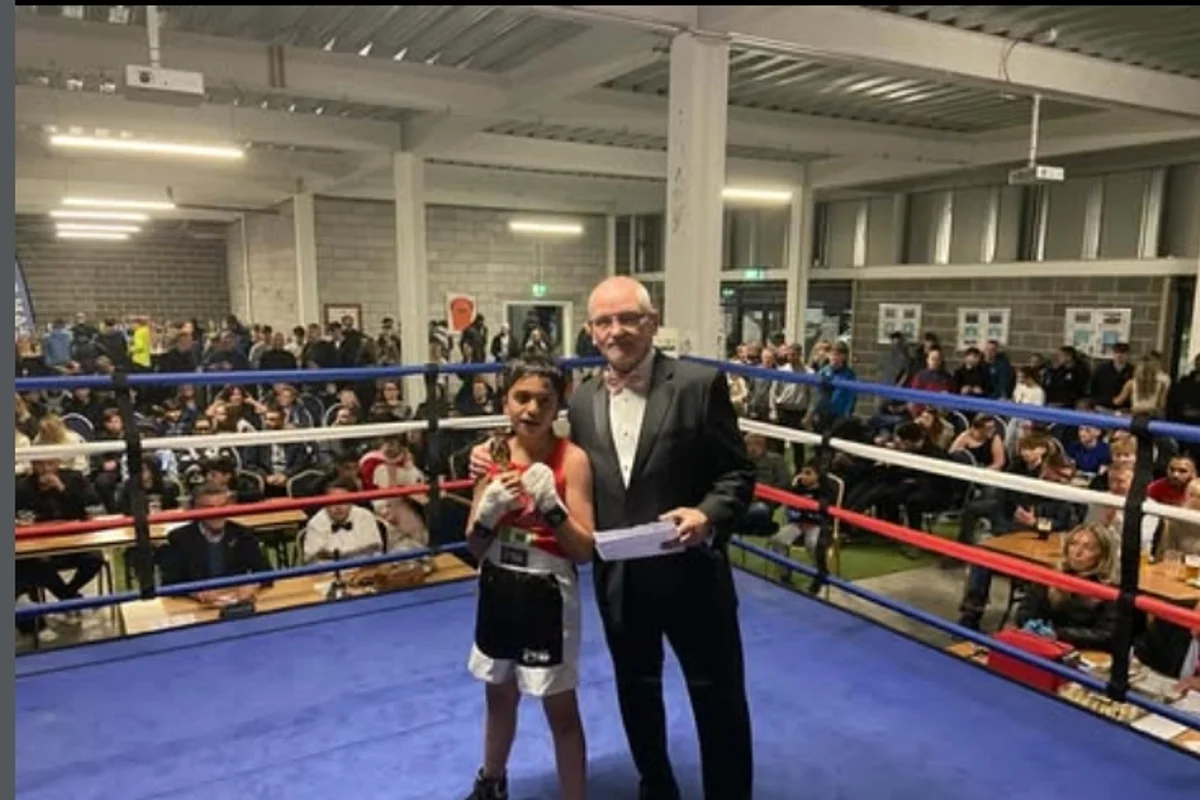 Junior amateur boxer with referee at ABA bout