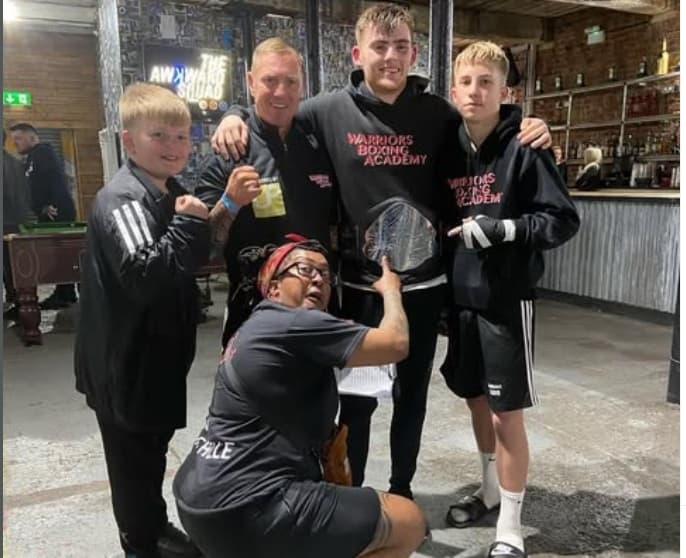 Warriors Boxing Academy boxers and coaches celebrating with trophies